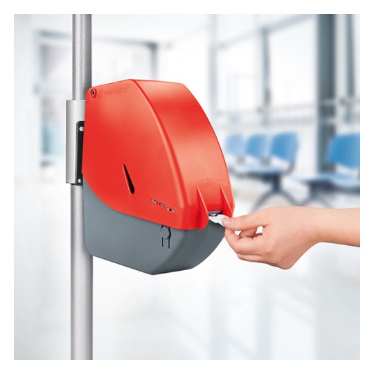 Dispenser i rødt og grått som deler ut kønummer. Designet er kompakt og funksjonelt, og brukes ofte i offentlige områder som sykehus, apotek eller kundeservicesentre.