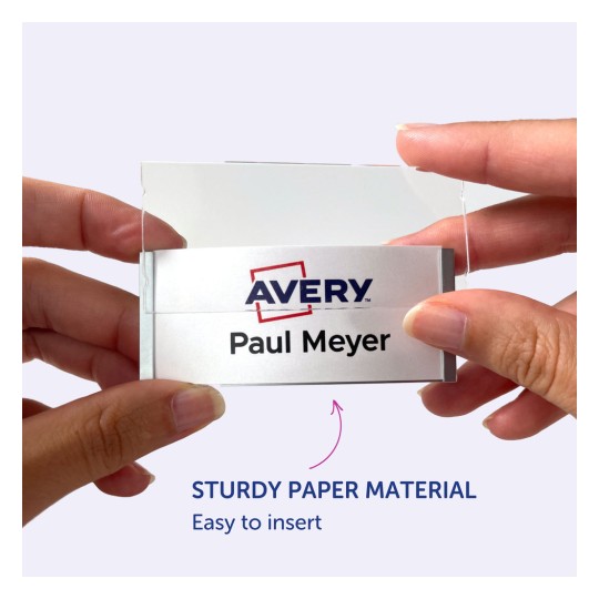 Bildet viser en person som holder et navneskilt med Avery-logoen og navnet 'Paul Meyer' på. Navneskiltet ser ut til å være enkelt å sette inn i en holder laget av robust papirmateriale.