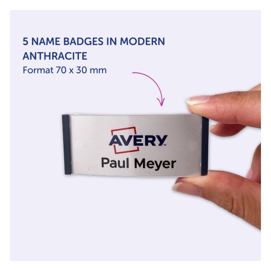 Bildet viser en person som holder et navneskilt hvor det står 'Avery Paul Meyer', og fremhever fem navneskilt i moderne antrasittfarge, med dimensjoner på 70 x 30 mm.