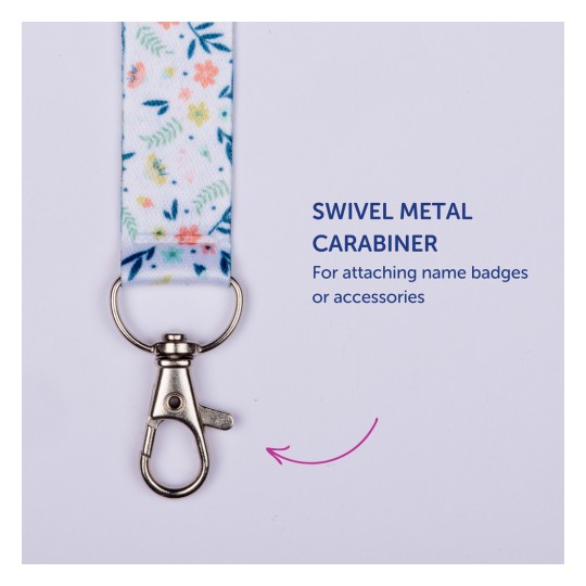 Bildet viser en fargerik nøkkelbånd med et blomsterdesign og en roterbar metallkarabinkrok, merket som 'Roterbar metallkarabinkrok for å feste navneskilt eller tilbehør'.