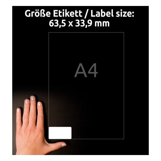 Størrelsessammenligning med hånd, Artikkel: J4773-10, ett ark værbestandige folie-etiketter, Format: 63,5 x 33,9 mm, Farge: Hvit.