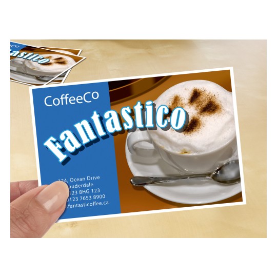 Bildet viser et reklamekort for en kaffebar med en cappuccino med skum og kakaopulver. På kortet står navnet 'CoffeeCo' og ordet 'Fantastico' fremhevet. Kontaktinformasjon og en nettside er også synlig.