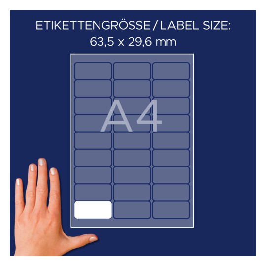Bildet viser et etikettark med dimensjonene 63,5 x 29,6 mm, designet for A4-format. En hånd er plassert ved siden av arket som referanse.