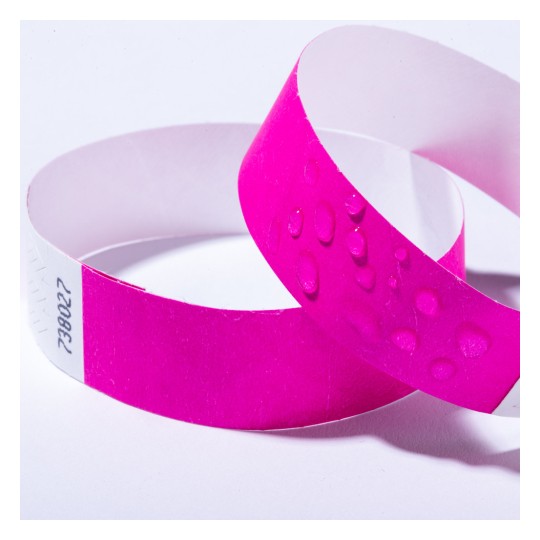 Bildet viser to rosa armbånd, ett med en teksturert overflate med små hevede prikker og det andre med et glatt utseende. Bakgrunnen er enkel og hvit.