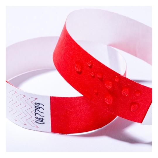 Bildet viser to armbånd, ett rødt og det andre en blanding av rødt og hvitt med et sikksakkmønster. Det røde armbåndet har vanndråper på overflaten.