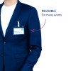 Bildet viser en person iført en marineblå blazer med en synlig navnelapp på brystet. Navnelappen viser navnet 'Tom Martin' og tittelen 'Prosjektleder'. En merknad peker på lappen og sier 'GJENBRUKBAR For mange arrangementer'.