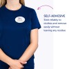 Bildet viser en person som har på seg en blå skjorte med en selvklebende navnelapp hvor det står 'B. Carlos, Markedsføringsdirektør'. Teksten fremhever den klebende egenskapen til navnelappen, og indikerer at den sitter godt fast og kan fjernes uten å etterlate rester.