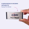 Bildet viser en person som holder et navneskilt hvor det står 'Avery Paul Meyer', og fremhever fem navneskilt i moderne antrasittfarge, med dimensjoner på 70 x 30 mm.
