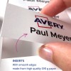 Bildet viser en hånd som holder et hvitt kort med navnet 'Paul Meyer' trykt på det, sammen med logoen til 'Avery'. Under finnes det tekst som lyder 'INNLEGG Med glatte kanter laget av høykvalitets 190 g papir'.