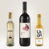 Bildet viser tre flasker: en flaske med eplebalsamico, en flaske med rødvin merket 'Night Owl', og en flaske med kremlikør. De er plassert på en lys bakgrunn.