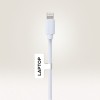 Bildet viser en hvit ladekabel med en Lightning-kontakt, merket med 'LAPTOP' på en etikett festet til kabelen.