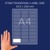 Bildet viser et etikettark med dimensjonene 63,5 x 29,6 mm, designet for A4-format. En hånd er plassert ved siden av arket som referanse.