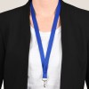 Bildet viser en person som har på seg en svart blazer over en hvit skjorte, med en blå nøkkelbånd rundt halsen.