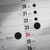 En kalenderblads side viser datoer med 'Peter' skrevet på den 24. Den markerer flere andre datoer med svarte sirkler.