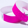 Bildet viser to rosa armbånd, ett med en teksturert overflate med små hevede prikker og det andre med et glatt utseende. Bakgrunnen er enkel og hvit.