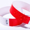 Bildet viser to armbånd, ett rødt og det andre en blanding av rødt og hvitt med et sikksakkmønster. Det røde armbåndet har vanndråper på overflaten.